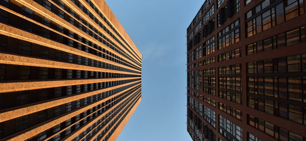 Low angle view two building against cloudy sky, symmetry